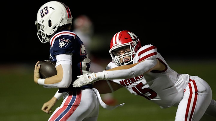Neenah High School's Connor Stuckel (15) tackles Appleton East's Alex Thompson (23) during a Fox Valley Association game Thursday, September 4, 2025.