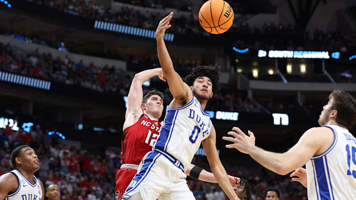 Mar 31, 2024; Dallas, TX, USA; Duke Blue Devils guard Jared McCain (0) reaches for the ball against North Carolina State Wolfpack guard Michael O'Connell (12) in the first half in the finals of the South Regional of the 2024 NCAA Tournament at American Airline Center. Mandatory Credit: Tim Heitman-Imagn Images Mar 31, 2024; Dallas, TX, USA; Duke Blue Devils guard Jared McCain (0) reaches for the ball against North Carolina State Wolfpack guard Michael O'Connell (12) in the first half in the finals of the South Regional of the 2024 NCAA Tournament at American Airline Center. Mandatory Credit: Tim Heitman-Imagn Images