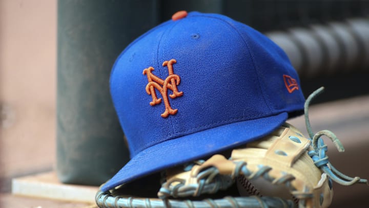 Jul 13, 2022; Atlanta, Georgia, USA; A detailed view of a New York Mets hat and glove in the dugout against the Atlanta Braves in the eighth inning at Truist Park. Mandatory Credit: Brett Davis-Imagn Images