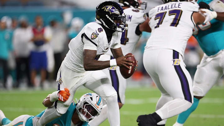 Baltimore Ravens quarterback Lamar Jackson (8) breaks loose of a tackle by Miami Dolphins linebacker Jaelan Phillips (15) during the first quarter at Hard Rock Stadium.