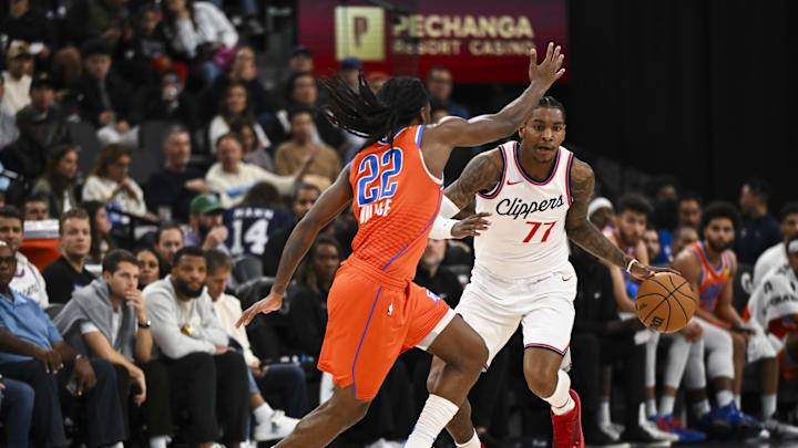 Nov 2, 2024; Inglewood, California, USA; LA Clippers guard Kevin Porter Jr. (77) drives the ball against Oklahoma City Thunder guard Cason Wallace (22) during the first half at Intuit Dome. Mandatory Credit: Jonathan Hui-Imagn Images