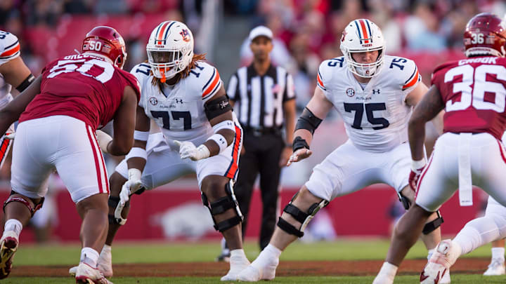 Nov 11, 2023; Fayetteville, Arkansas, USA;  Auburn Tigers offensive lineman Jeremiah Wright (77) and offensive lineman Connor Lew (75) block during the first quarter against the Arkansas Razorbacks at Donald W. Reynolds Razorback Stadium. Auburn won 48-10. Mandatory Credit: Brett Rojo-Imagn Images