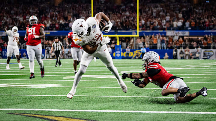 Texas Longhorns running back Jaydon Blue runs around defense from Ohio State Buckeyes safety Lathan Ransom for a touchdown.
