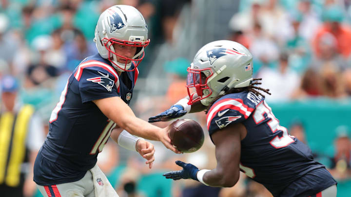 New England Patriots running back Rhamondre Stevenson takes a handoff from quarterback Drake Maye.