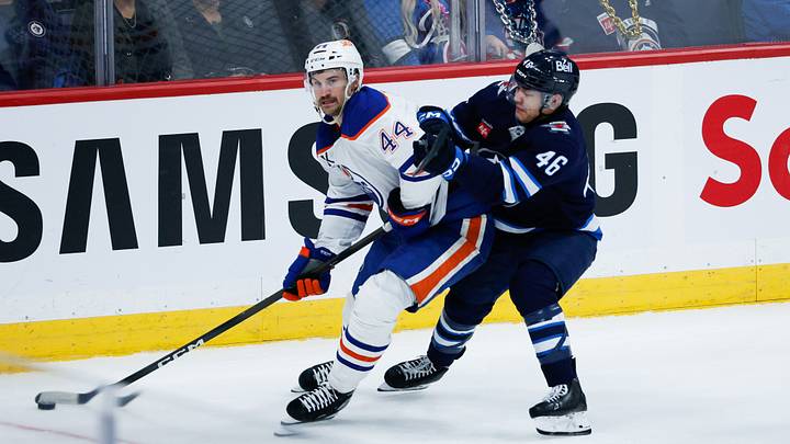Sep 22, 2026; Winnipeg, Manitoba, CAN;  Edmonton Oilers defenseman Joshua Brown (44) tries to skate away from Winnipeg Jets forward Kevin He (46) during the third period at Canada Life Centre.  Mandatory Credit: Terrence Lee-Imagn Images
