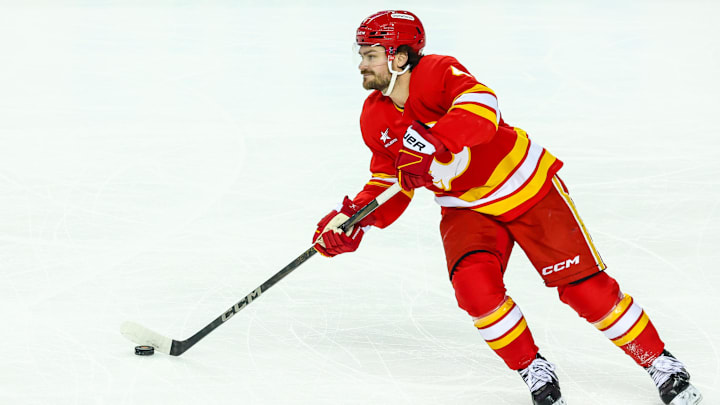 Apr 13, 2025; Calgary, Alberta, CAN; Calgary Flames defenseman Rasmus Andersson (4) skates with the puck against the San Jose Sharks during the first period at Scotiabank Saddledome. Mandatory Credit: Sergei Belski-Imagn Images
