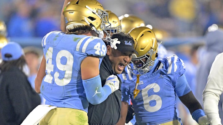 Nov 8, 2024; Pasadena, California, USA;   UCLA Bruins defensive coordinator Ikaika Malloe, center, celebrates with linebacker Carson Schwesinger (49) defensive back Jaylin Davies (6) after an interception in the second half against the Iowa Hawkeyes at the Rose Bowl. Mandatory Credit: Jayne Kamin-Oncea-Imagn Images