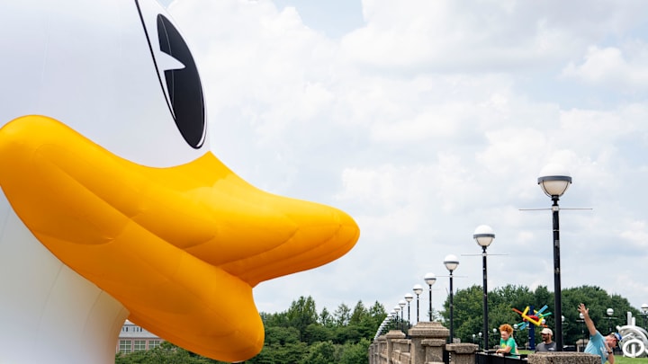 Bypassers look at and take photos with an inflatable University of Oregon Duck mascot on the White River in front of the NCAA Headquarters on Tuesday, July 23, 2024, in downtown Indianapolis. The float weighs in at 1,600 pounds and takes 1.5 hours to inflate.