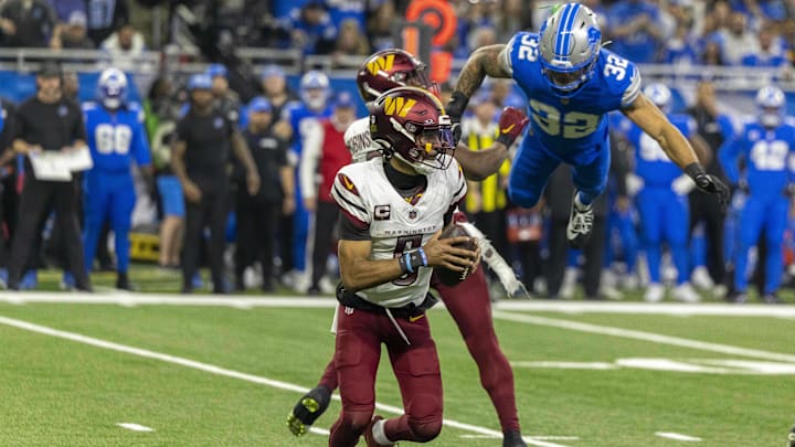 Jan 18, 2025; Detroit, Michigan, USA; Washington Commanders quarterback Jayden Daniels (5) looks to pass as running back Brian Robinson Jr. (8) defends against Detroit Lions defensive back Brian Branch (32) during the second half at Ford Field. Jan 18, 2025; Detroit, Michigan, USA; Washington Commanders quarterback Jayden Daniels (5) looks to pass as running back Brian Robinson Jr. (8) defends against Detroit Lions defensive back Brian Branch (32) during the second half at Ford Field.