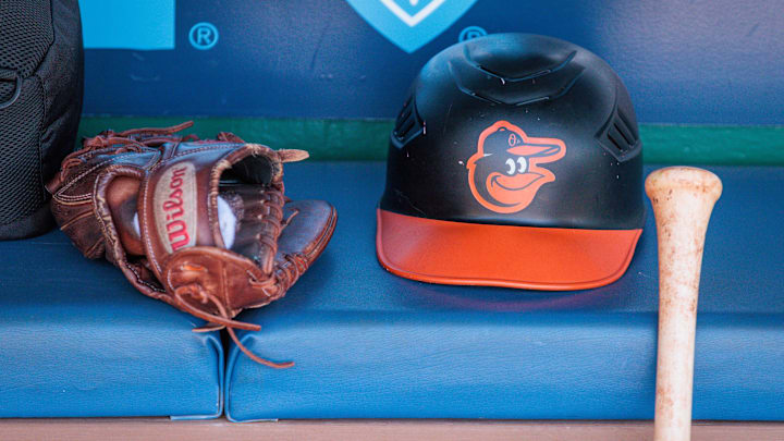 Apr 21, 2024; Kansas City, Missouri, USA; Baltimore Orioles hat and glove sits in the dugout during the ninth inning against the Kansas City Royals at Kauffman Stadium. Mandatory Credit: William Purnell-Imagn Images