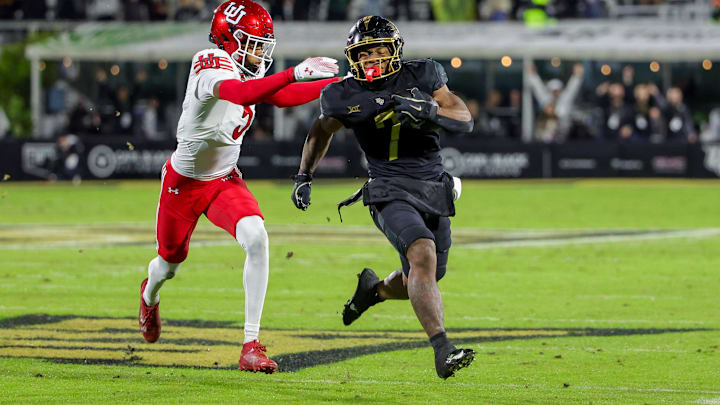 UCF Knights running back RJ Harvey carries the ball as Utah Utes cornerback Smith Snowden moves in UCF Knights running back RJ Harvey carries the ball as Utah Utes cornerback Smith Snowden moves in