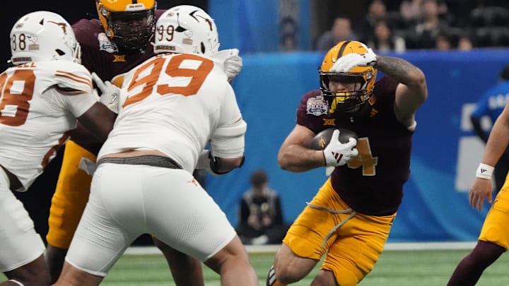 Arizona State running back Cam Skattebo (4) cuts past Texas defensive lineman Jermayne Lole (99) during the first quarter of the Chick-fil-A Peach Bowl