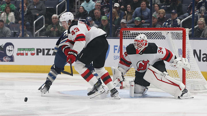 New Jersey Devils defenseman Luke Hughes (43) picks up a loose puck from goalie Jake Allen (34). Mandatory Credit: Russell LaBounty-Imagn Images