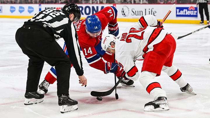 Apr 1, 2023; Montreal, Quebec, CAN; NHL linesman Mark Shewchyk (92) drops the puck at face-off between Montreal Canadiens center Nick Suzuki (14) and Carolina Hurricanes center Sebastian Aho (20) during the first period at Bell Centre. Mandatory Credit: David Kirouac-Imagn Images