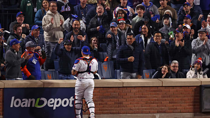 New York City, New York, USA; A New York Mets fan reacts with catcher Francisco Alvarez (4) after making a catch in the third inning during game four of the NLCS for the 2024 MLB playoffs at Citi Field.