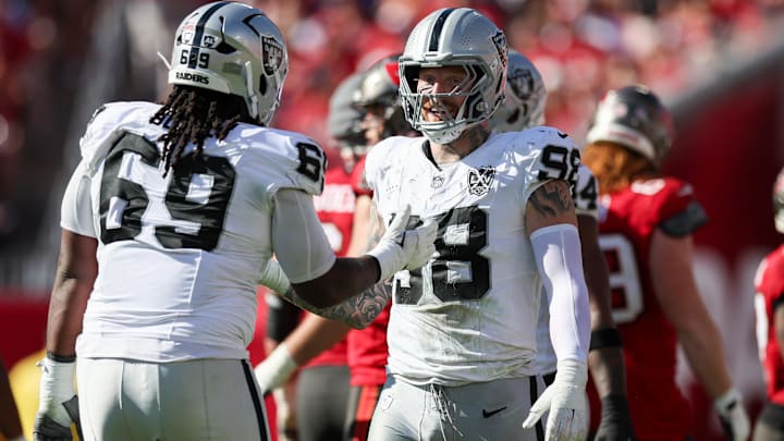 Dec 8, 2024; Tampa, Florida, USA; Las Vegas Raiders defensive end Maxx Crosby (98) and defensive tackle Adam Butler (69) reacts after a play against the Tampa Bay Buccaneers in the second quarter at Raymond James Stadium. Mandatory Credit: Nathan Ray Seebeck-Imagn Images