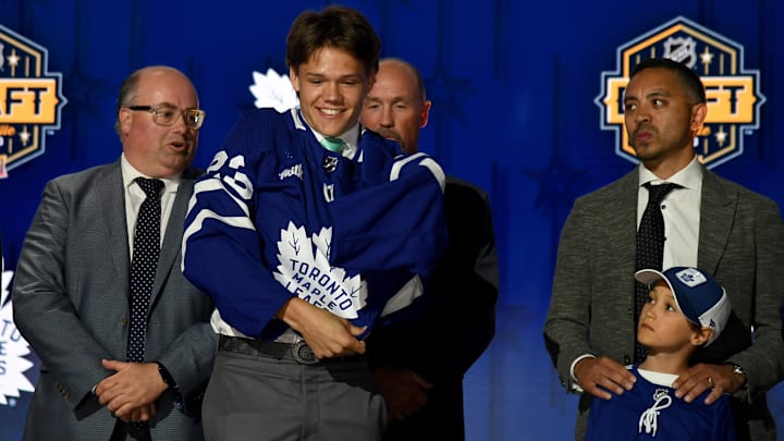 Jun 28, 2023; Nashville, Tennessee, USA; Toronto Maple Leafs draft pick Easton Cowan puts on his sweater after being selected with the twenty eighth pick in round one of the 2023 NHL Draft at Bridgestone Arena. Mandatory Credit: Christopher Hanewinckel-Imagn Images