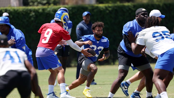 Jul 31, 2024; Los Angeles, CA, USA;  Los Angeles Rams quarterback Matthew Stafford (9) hands a ball off to running back Kyren Williams (23) in jog through during training camp at Loyola Marymount University. Mandatory Credit: Kiyoshi Mio-Imagn Images