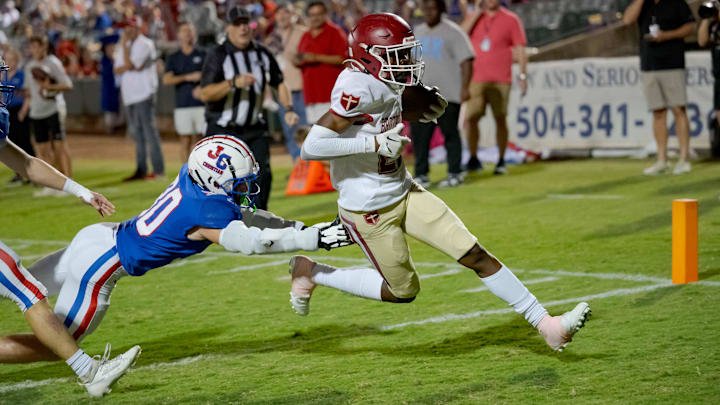 Oct 27, 2023; Metairie, LA, USA; Brother Martin Crusaders wide receiver Easton Royal (23) scores a touchdown against John Curtis Patriots linebacker Benjamin Barron (30) during the first quarter at The Shrine on Airline. Mandatory Credit: Matthew Hinton-Imagn Images