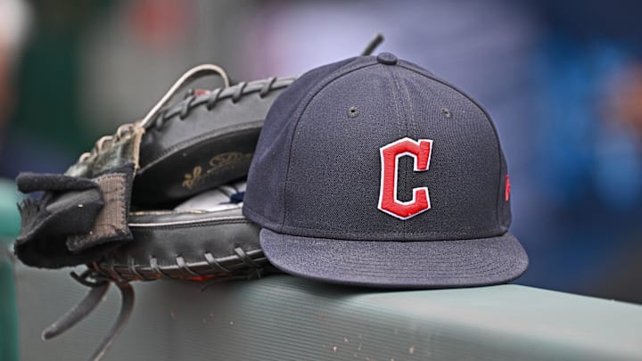 Jun 27, 2024; Kansas City, Missouri, USA; A general view a Cleveland Guardians hat and glove on the dugout railing  before a game against the Kansas City Royals at Kauffman Stadium. Mandatory Credit: Peter Aiken-Imagn Images