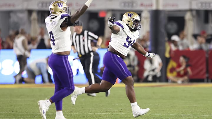 Huskies defensive lineman Jayvon Parker (94) celebrates with edge rusher Zion Tupuola-Fetui (4) after the UW beat USC 52-42 in Los Angeles in 2023.