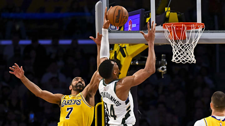 Mar 20, 2025; Los Angeles, California, USA; Los Angeles Lakers guard Gabe Vincent (7) attempts to block Milwaukee Bucks forward Giannis Antetokounmpo (34) during the second half at Crypto.com Arena. Mandatory Credit: Jonathan Hui-Imagn Images