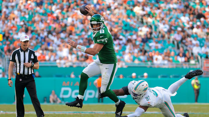Dec 8, 2024; Miami Gardens, Florida, USA; New York Jets quarterback Aaron Rodgers (8) breaks a tackle against Miami Dolphins linebacker Emmanuel Ogbah (91) during the second quarter at Hard Rock Stadium. 