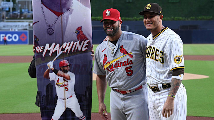 San Diego Padres third baseman Manny Machado (right) and St. Louis Cardinals designated hitter Albert Pujols (5) pose for a photograph after the Padres gifted Pujols a surfboard in honor of his end-of-season retirement before the game at Petco Park on Sept. 20, 2022. San Diego Padres third baseman Manny Machado (right) and St. Louis Cardinals designated hitter Albert Pujols (5) pose for a photograph after the Padres gifted Pujols a surfboard in honor of his end-of-season retirement before the game at Petco Park on Sept. 20, 2022.