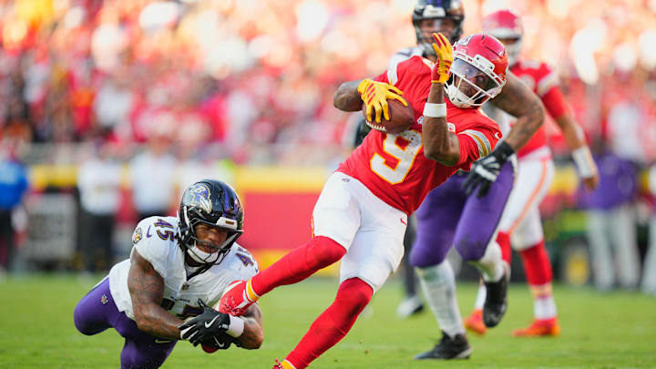 Sep 28, 2025; Kansas City, Missouri, USA; Kansas City Chiefs wide receiver JuJu Smith-Schuster (9) attempts to evade a tackle from Baltimore Ravens linebacker Mike Green (45) during the third quarter at GEHA Field at Arrowhead Stadium. Mandatory Credit: Jay Biggerstaff-Imagn Images