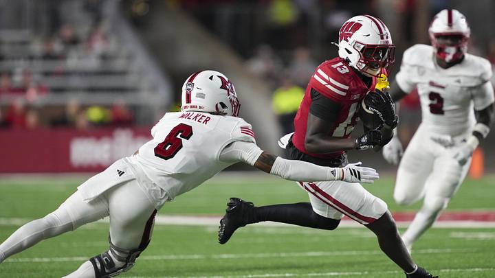 Aug 28, 2025; Madison, Wisconsin, USA;  Wisconsin Badgers wide receiver Eugene Hilton Jr. (13) rushes with the football against Miami (OH) RedHawks defensive back Adrian Walker Jr. (6) during the third quarter at Camp Randall Stadium. Mandatory Credit: Jeff Hanisch-Imagn Images