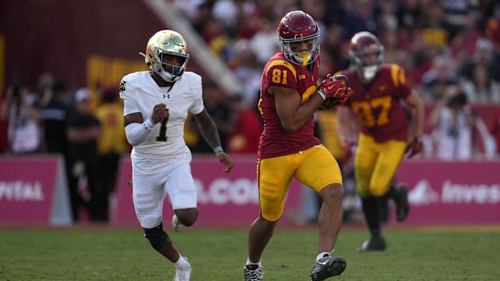 Nov 30, 2024; Los Angeles, California, USA; Southern California Trojans wide receiver Kyle Ford (81) carries the ball against Notre Dame Fighting Irish safety Jordan Clark (1) in the second half at United Airlines Field at Los Angeles Memorial Coliseum. 