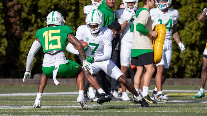 Oregon wide receiver Evan Stewart attempts to avoid defensive back Solomon Davis during practice.