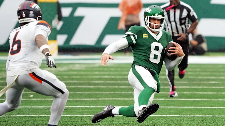 Sep 29, 2024; East Rutherford, New Jersey, USA;  New York Jets quarterback Aaron Rodgers (8) scrambles against Denver Broncos safety P.J. Locke (6) during the second half at MetLife Stadium. 