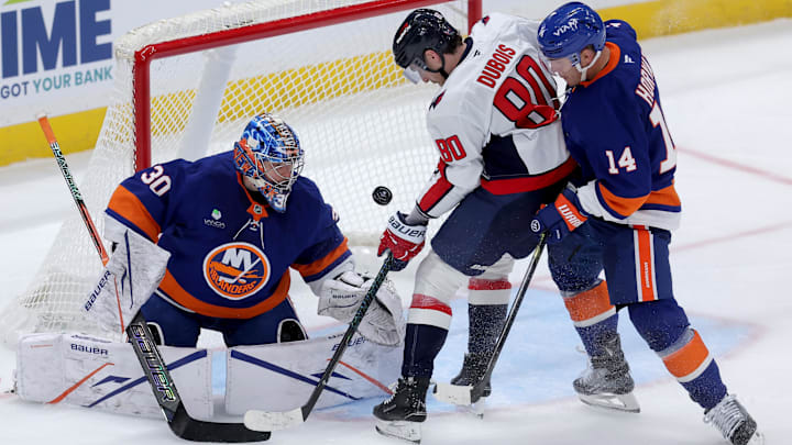 Oct 11, 2025; Elmont, New York, USA; Washington Capitals left wing Pierre-Luc Dubois (80) plays the puck against New York Islanders goaltender Ilya Sorokin (30) and center Bo Horvat (14) during the third period at UBS Arena. Mandatory Credit: Brad Penner-Imagn Images