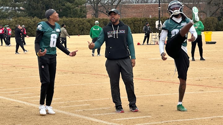 Eagles secondary coach Christian Parker chats up DeVonta Smith at practice.