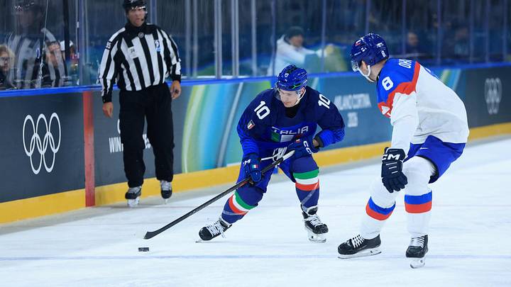 Feb 13, 2026; Milan, Italy; Dustin Gazley of Italy in action with Oliver Okuliar of Slovakia during a Group B men's ice hockey game during the Milano Cortina 2026 Olympic Winter Games at Milano Rho Ice Hockey Arena. Mandatory Credit: Katie Stratman-Imagn Images
