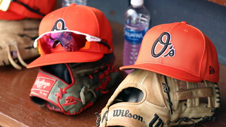 Mar 11, 2024; Tampa, Florida, USA; A detailed view of Baltimore Orioles baseball hats and gloves in the dugout during the first inning against the New York Yankees at George M. Steinbrenner Field. Mar 11, 2024; Tampa, Florida, USA; A detailed view of Baltimore Orioles baseball hats and gloves in the dugout during the first inning against the New York Yankees at George M. Steinbrenner Field.