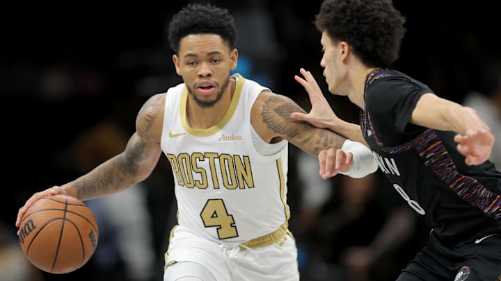 Jan 23, 2026; Brooklyn, New York, USA; Boston Celtics guard Anfernee Simons (4) brings the ball up court against Brooklyn Nets guard Nolan Traore (88) during the first quarter at Barclays Center. Mandatory Credit: Brad Penner-Imagn Images