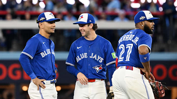 Oct 13, 2025; Toronto, Ontario, CAN; Toronto Blue Jays second baseman Andres Gimenez (0) and third baseman Ernie Clement (22) and first baseman Vladimir Guerrero Jr. (27) look on in the seventh inning against the Seattle Mariners during game two of the ALCS round for the 2025 MLB playoffs at Rogers Centre. 