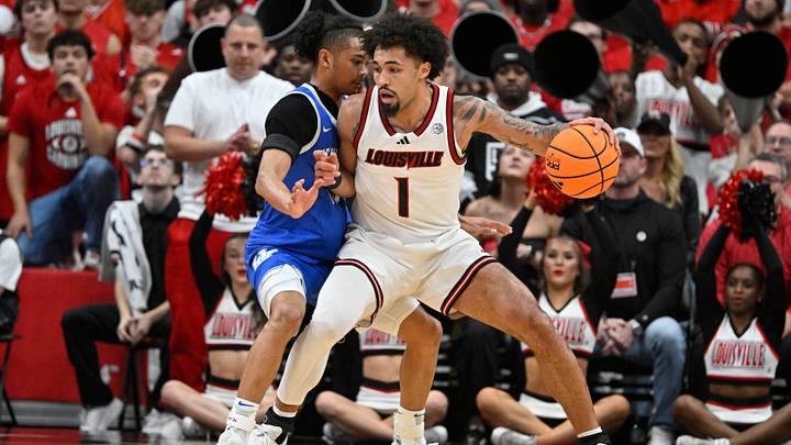 Nov 11, 2025; Louisville, Kentucky, USA; Louisville Cardinals guard J'Vonne Hadley (1) dribbles the ball defended by Kentucky Wildcats guard Jaland Lowe (15) during the first half at KFC Yum! Center. Louisville defeated Kentucky 96-88. Mandatory Credit: Jamie Rhodes-Imagn Images