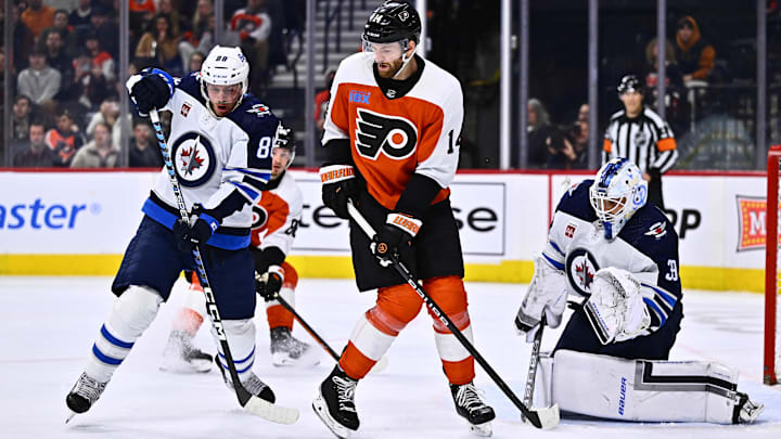 Feb 8, 2024; Philadelphia, Pennsylvania, USA; Philadelphia Flyers center Sean Couturier (14) attempts to deflect a shot against Winnipeg Jets defenseman Nate Schmidt (88) and goalie Laurent Brossoit (39) in the third period at Wells Fargo Center.