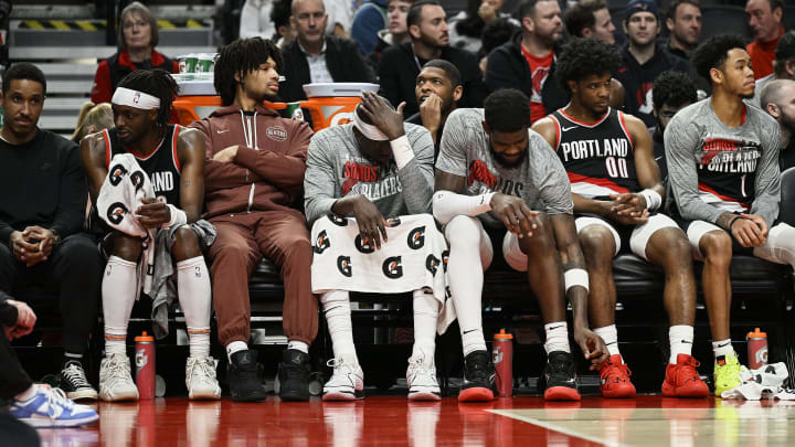 Mar 11, 2024; Portland, Oregon, USA; The Portland Trail Blazers bench, from left, guard Malcolm Brogdon (11), guard Shaedon Sharpe (17), center Duop Reath (26), center Deandre Ayton (2), guard Scoot Henderson (00), and guard Anfernee Simons (1) watch the final minutes of a game against the Boston Celtics at Moda Center. Mandatory Credit: Troy Wayrynen-USA TODAY Sports