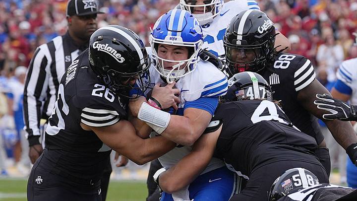 Iowa State Cyclones' linebacker Caleb Bacon (26) and linebacker Kooper Ebel (47) takes down BYU Cougars quarterback Bear Bachmeier (47) during the first quarter at Jack Trice Stadium on Oct. 25, 2025, in Ames, Iowa.