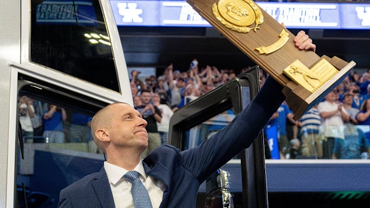 Mark Pope exits the bus with holding a trophy as he enters Rupp Arena greeting thousands of fans for his introductory press conference on Sunday, April 14, 2024.