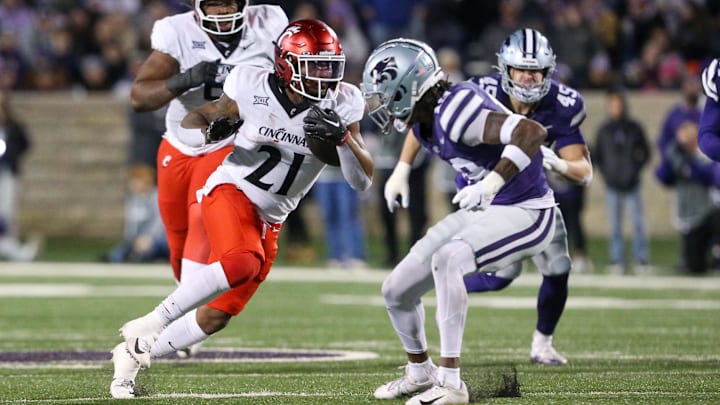 Nov 23, 2024; Manhattan, Kansas, USA; Cincinnati Bearcats running back Corey Kiner (21) tries to run by Kansas State Wildcats safety VJ Payne (19) during the second quarter at Bill Snyder Family Football Stadium. Mandatory Credit: Scott Sewell-Imagn Images