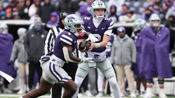 Nov 29, 2025; Manhattan, Kansas, USA; Kansas State Wildcats running back Joe Jackson (4) takes the handoff from quarterback Avery Johnson (2) during the fourth quarter at Bill Snyder Family Football Stadium. Mandatory Credit: Scott Sewell-Imagn Images