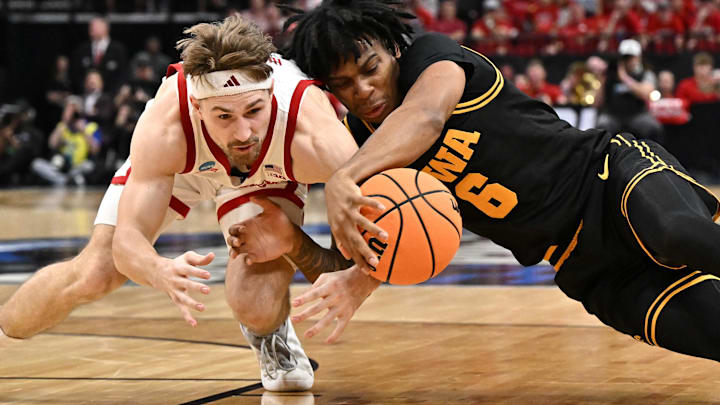 Nebraska Cornhuskers guard Sam Hoiberg and Iowa Hawkeyes guard Tavion Banks dive for a loose ball.