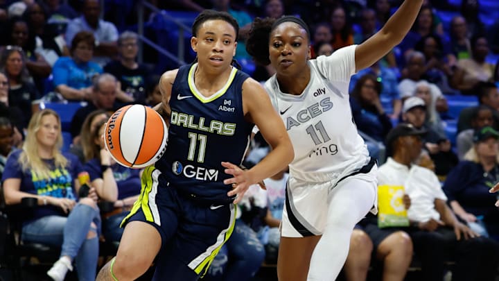 Jul 16, 2025; Arlington, Texas, USA;  Dallas Wings guard JJ Quinerly (11) drives to the basket against Las Vegas Aces guard Dana Evans (11) during the second half at College Park Center. Mandatory Credit: Chris Jones-Imagn Images