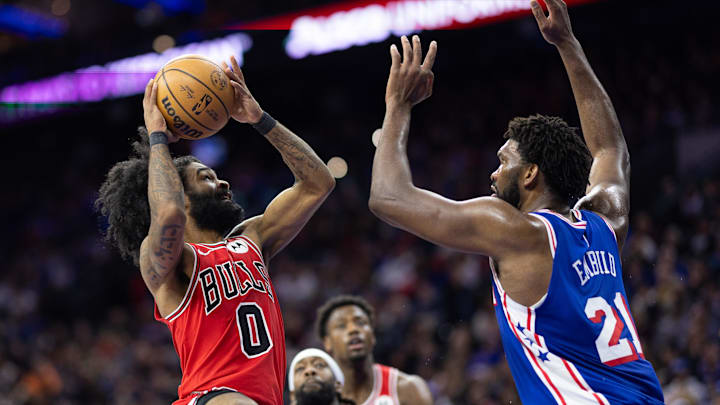Jan 2, 2024; Philadelphia, Pennsylvania, USA; Chicago Bulls guard Coby White (0) drives against Philadelphia 76ers center Joel Embiid (21) during the third quarter at Wells Fargo Center. Mandatory Credit: Bill Streicher-Imagn Images