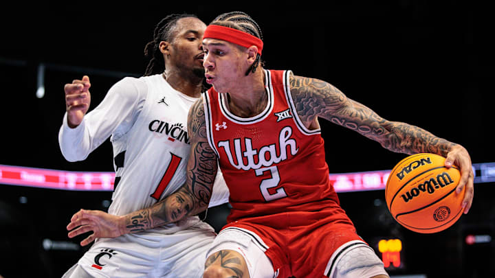 Mar 10, 2026; Kansas City, MO, USA; Utah Utes guard Terrence Brown (2) drives around Cincinnati Bearcats guard Day Day Thomas (1) during the second half at T-Mobile Center. Mandatory Credit: William Purnell-Imagn Images